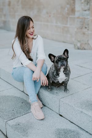 Woman with cute bulldog on street