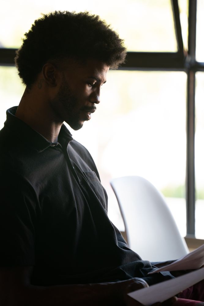 Close up man by window looking at his notes