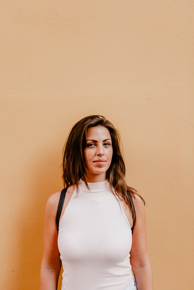 Young brunette standing against orange background