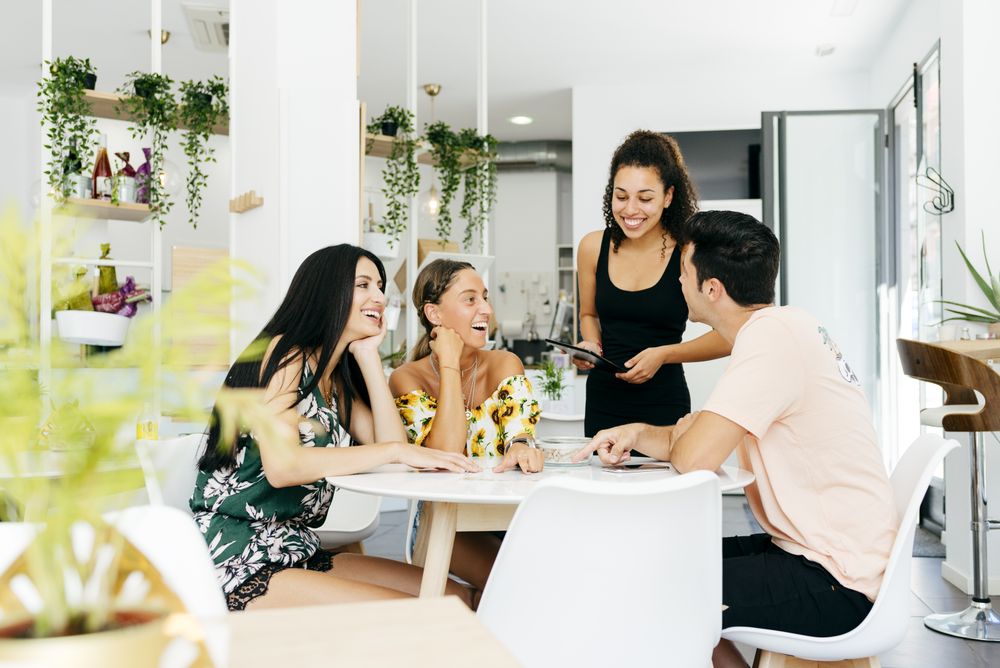 Friends making order in modern cafe