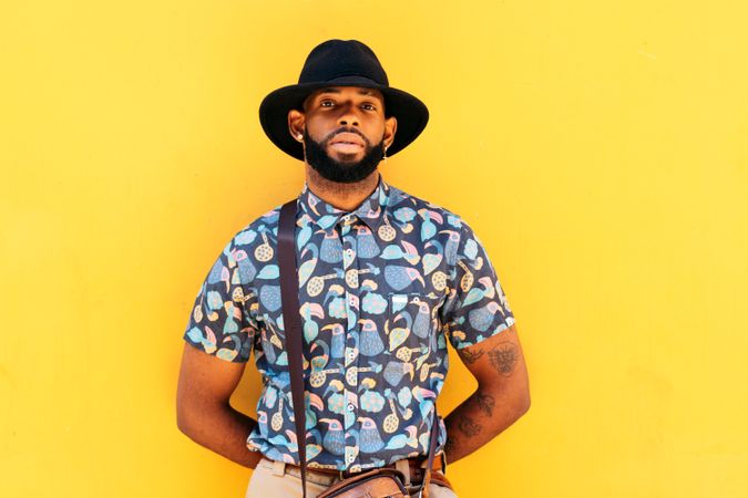 Stylish Black man outdoors over yellow background