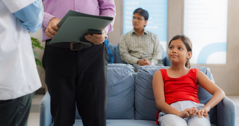 Worried Girl Feeling Relieved after Hearing Good News from her Family Doctor in a Clinic