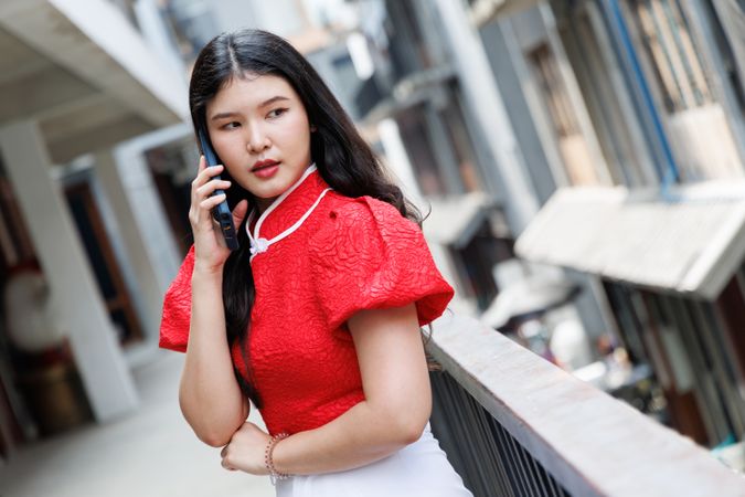 Asian female talking on mobile phone standing in the city