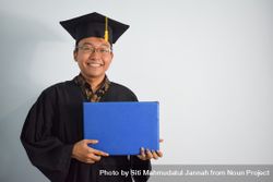 Smiling male graduate in studio shoot holding certificate 47meAg