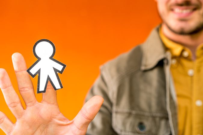 Smiling man holding funny paper toy