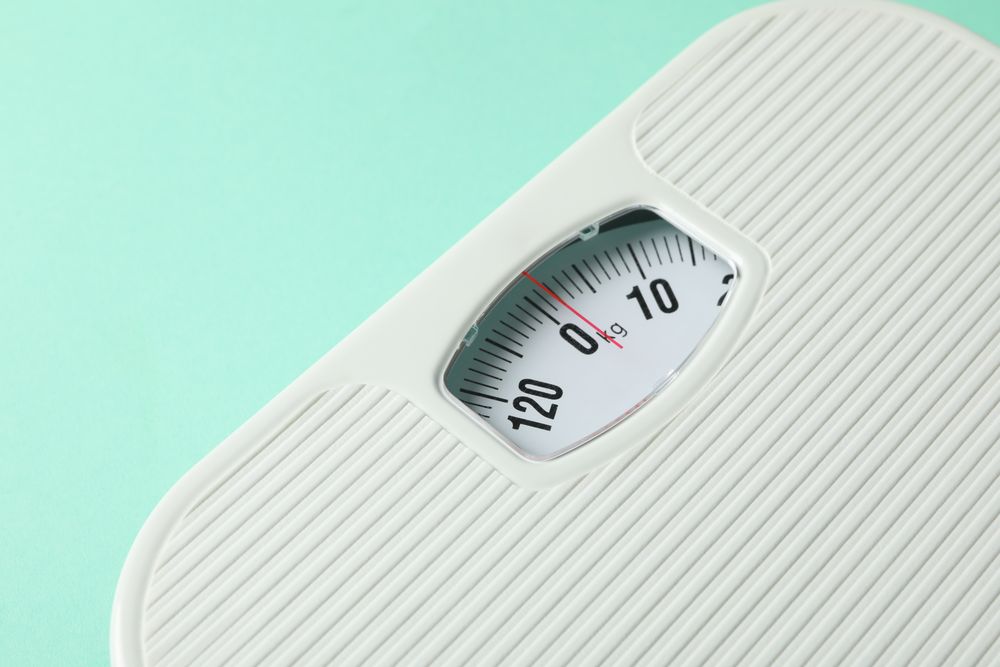 weight scales on mint background. Weight loss concept