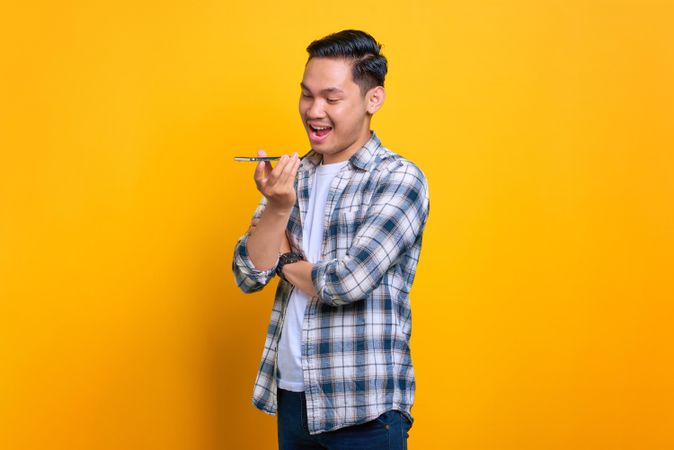 Asian male explaining something on speaker phone in studio shoot