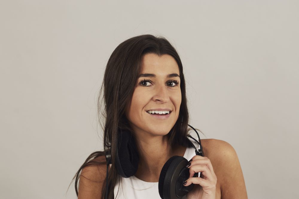 Thoughtful young woman enjoying music in studio