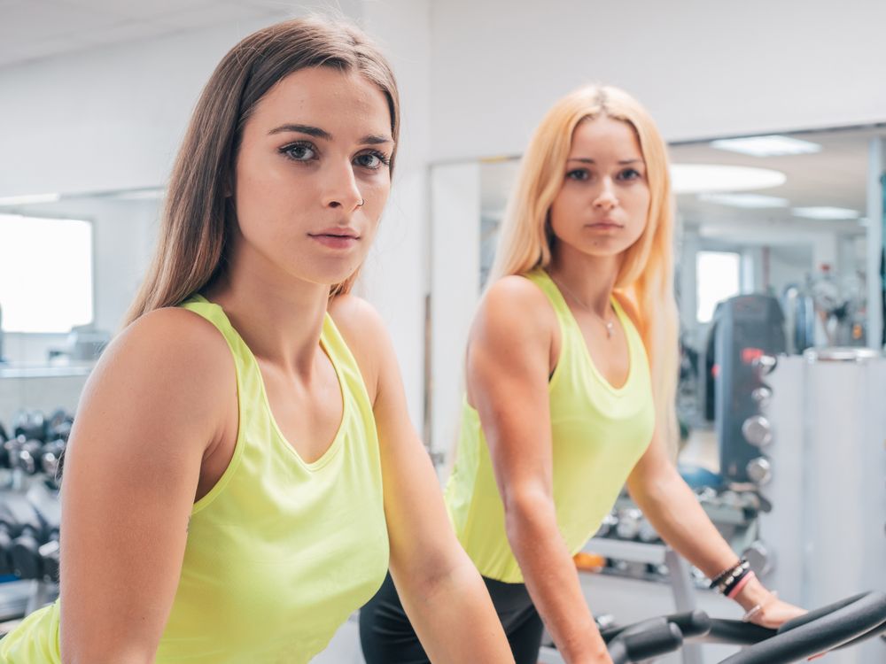 Young women exercising on machines together