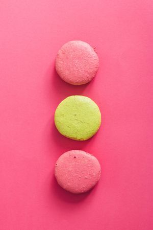 French macaron in rows on bright pink background