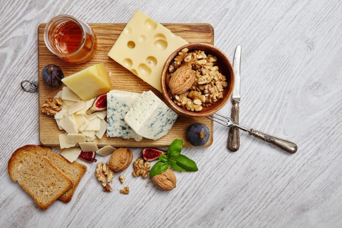 Top view of cheese plate on wooden board with toast