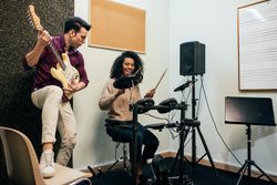 Man playing guitar and woman playing drums