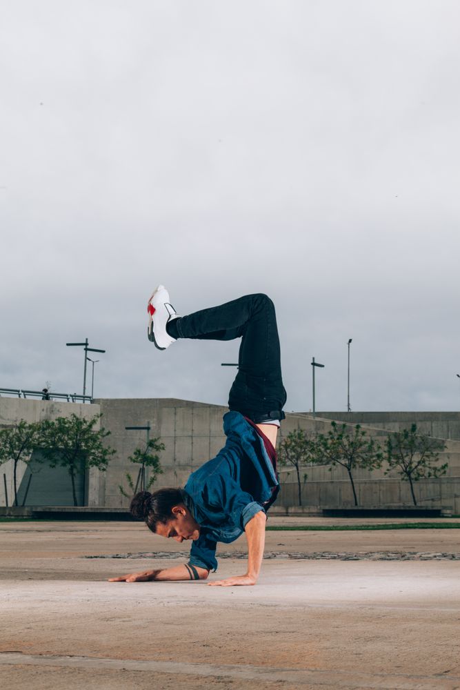 Skillful break dancer performing handstand while moving