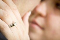 Female Hand with Engagement Ring Touching Fiance's Face
