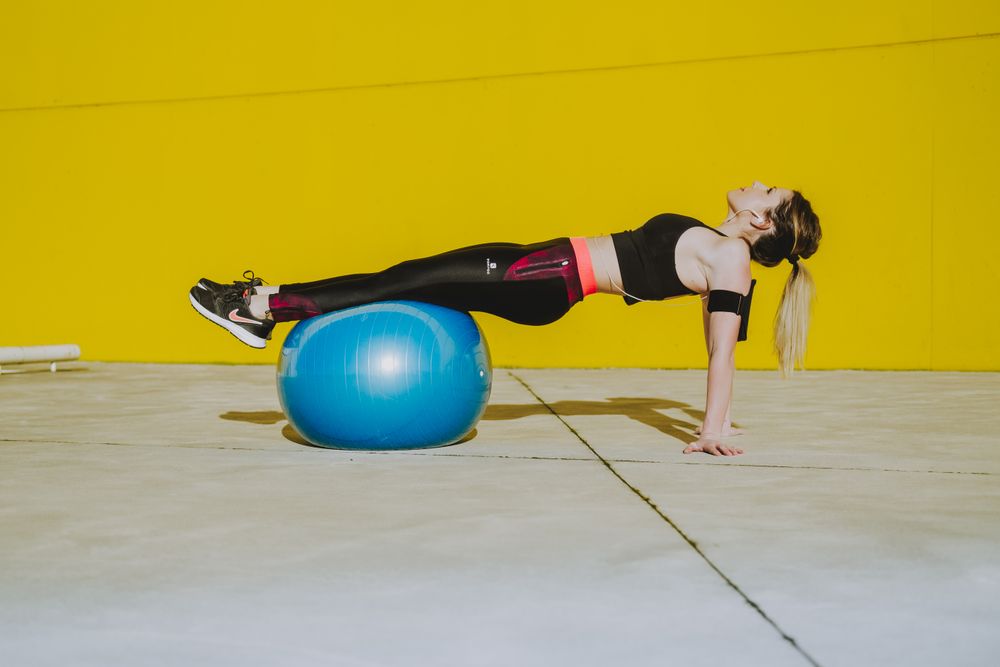 Woman doing plank with legs on ball