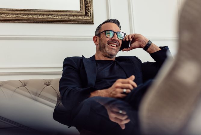 Businessman relaxing in hotel room and making phone call