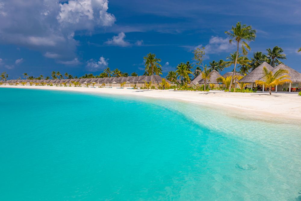 Beautiful beach with a blue sky with clouds and waterfront villas