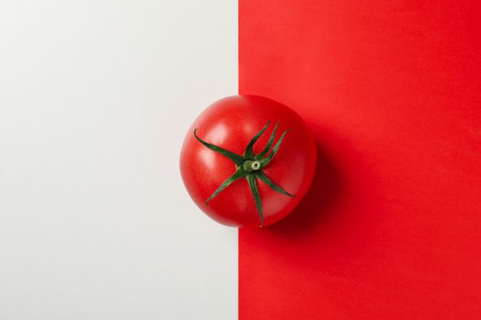 Fresh tomato on two tone background, top view