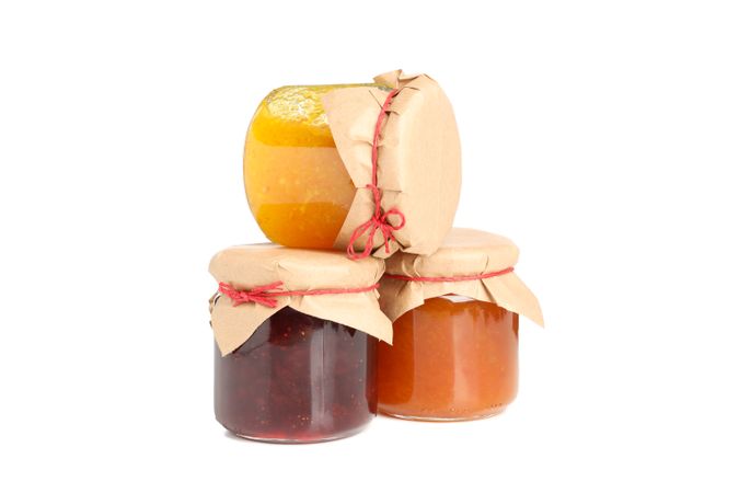 Glass jars with jam isolated on blank background