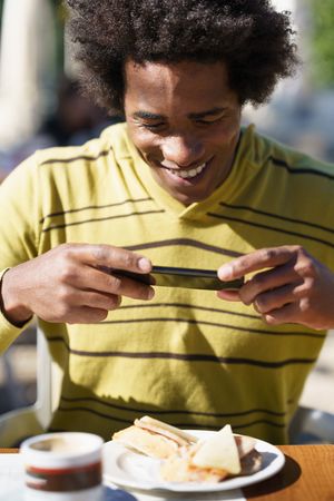Man taking picture of his meal at a cafe