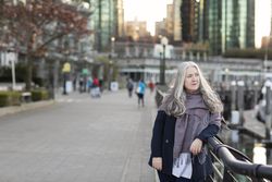 Woman with gray hair leaning on a railing