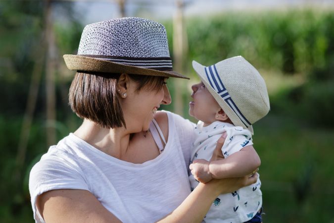 Adorable mother and child on hand enjoying and laughing in field