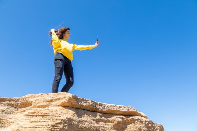 female taking photo of rocky landscape