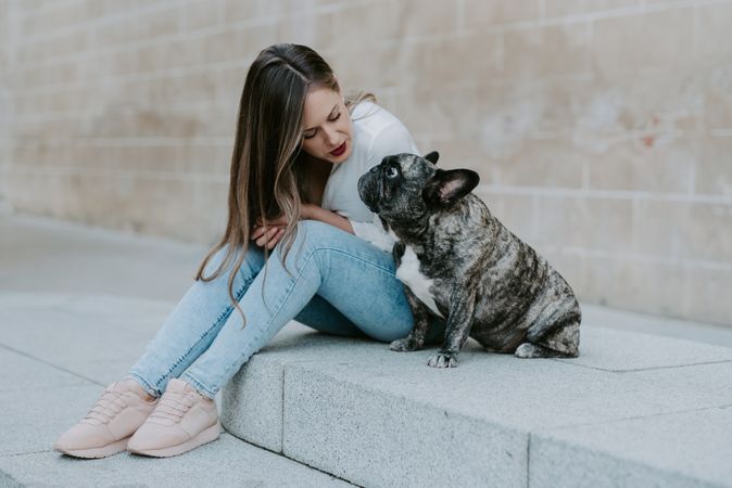 Woman with cute bulldog on street