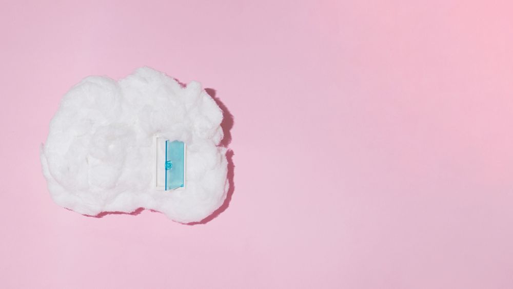 Single cotton cloud with blue door on pink background with copy space