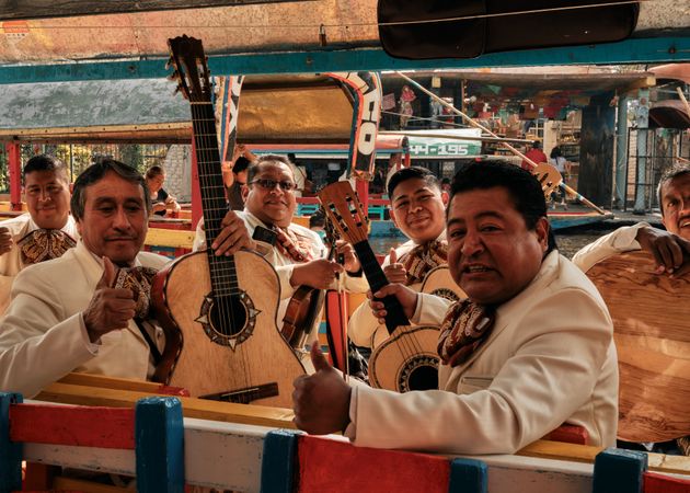Smiling mariachi band on boat in river in Mexico