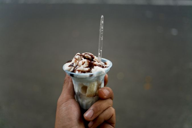 Hand holding chocolate topped ice cream treat