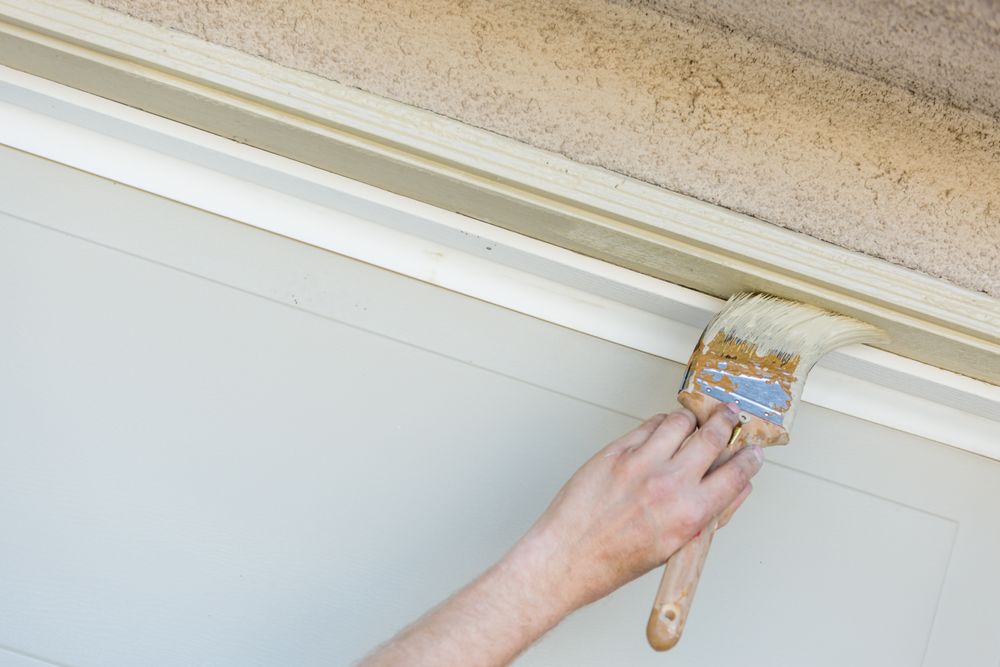 Professional Painter Cutting In With Brush to Paint Garage Door Frame