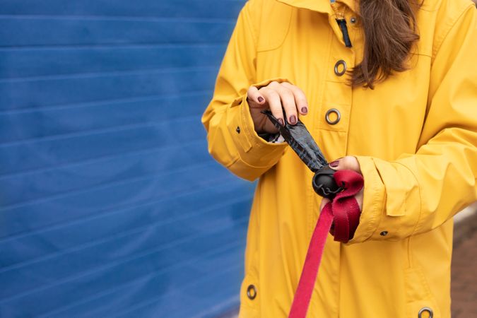 Woman opening a dust bin bag for dog poop in street
