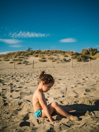 Girl playing on beach in sunny day