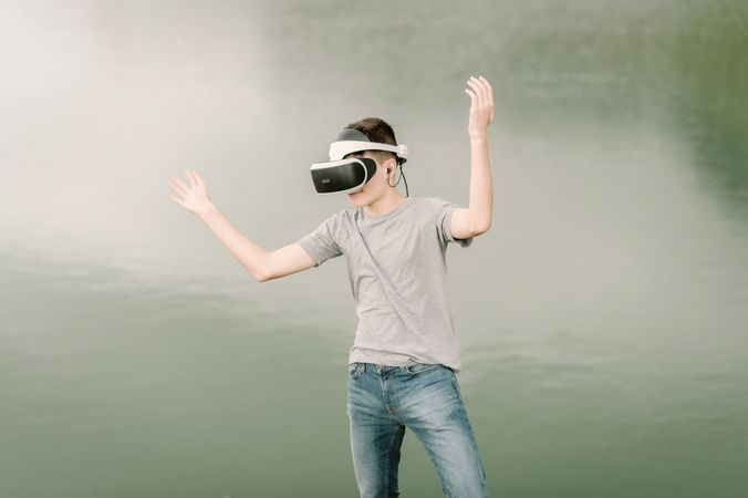 Young teenager with virtual reality glasses outdoors