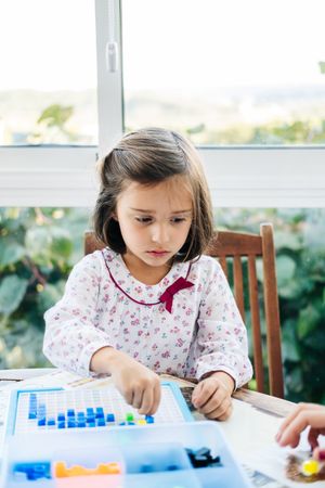 Girl playing with mosaic board game