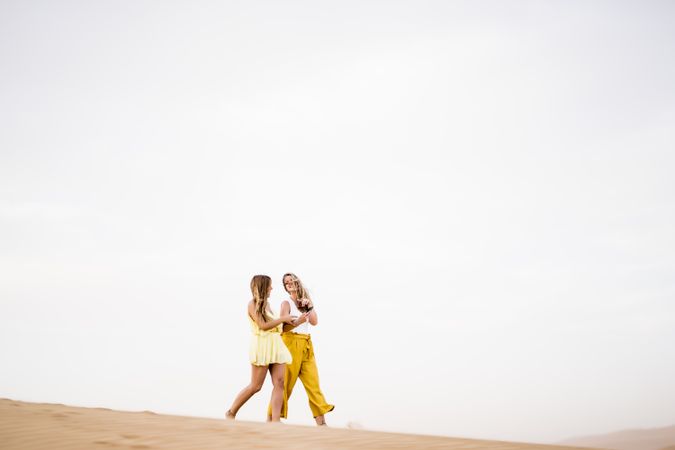 Happy women walking in the desert in desert