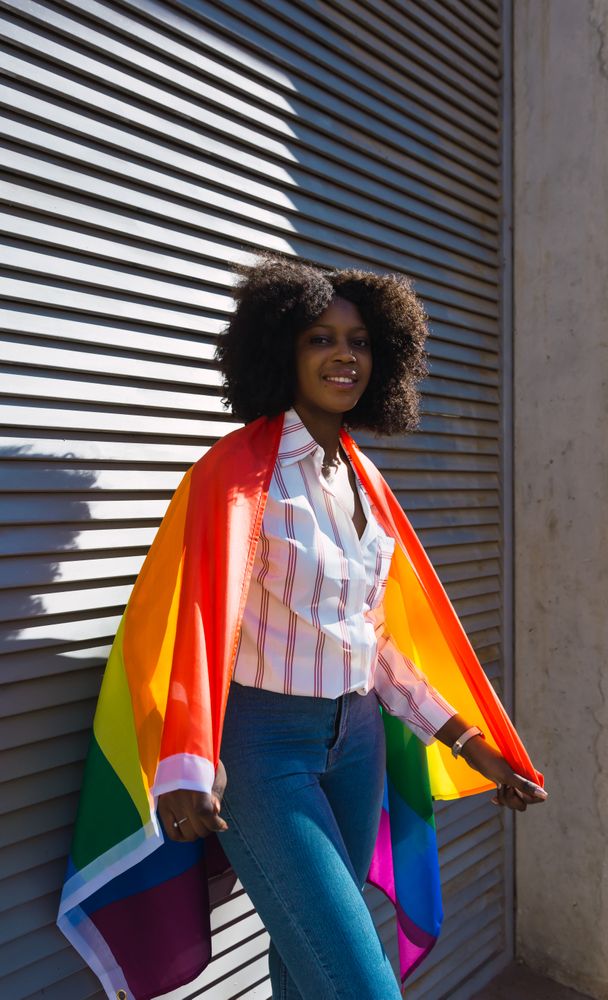 Female posing happily with the LGBT flag