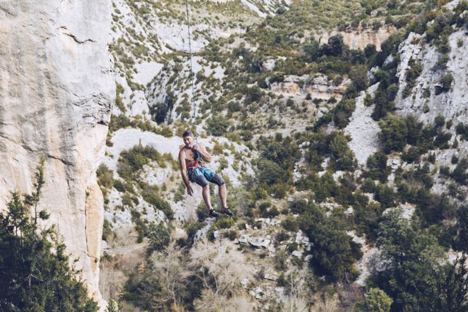 Anonymous climber handing on cliff