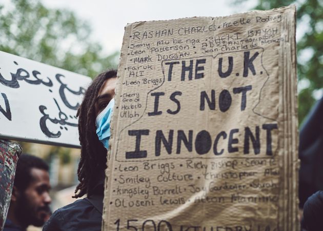 London, England, United Kingdom - June 6th, 2020: Young man at BLM protest with sign covering face