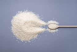 Rice pile and a wooden spoon full of rice