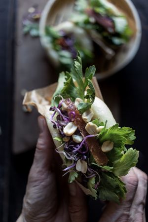 Crop person having traditional Gua Bao sandwich
