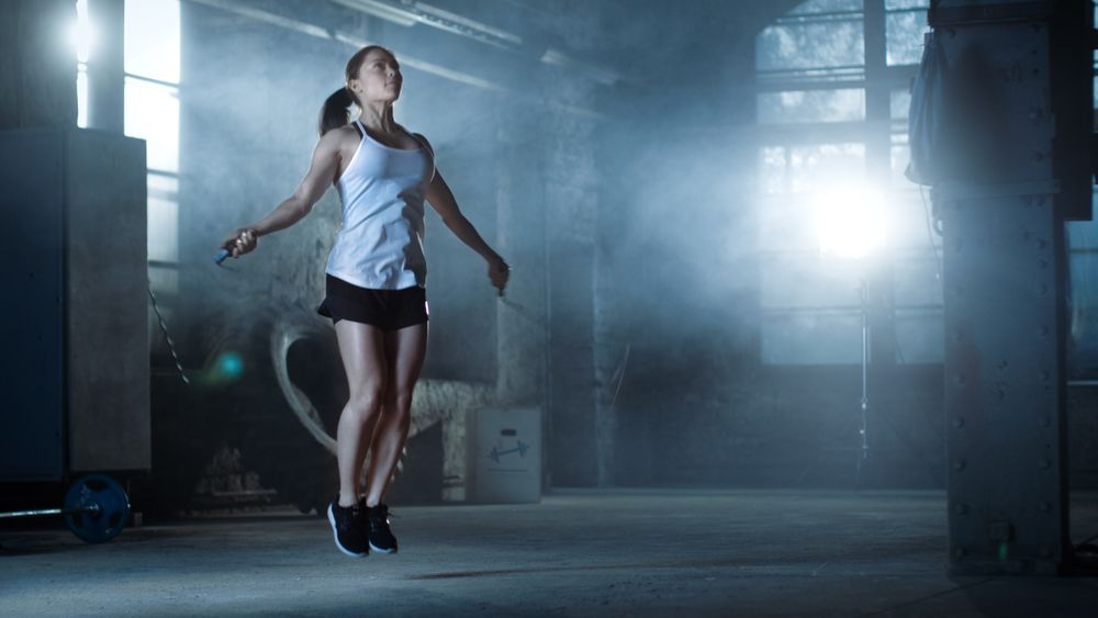 Athletic Woman Exercises with Jump   Skipping Rope in a Gym.