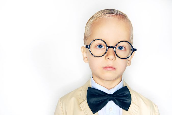 Serious blond boy in glasses and bow tie