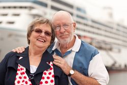 Older Couple On Shore in Front of Cruise Ship