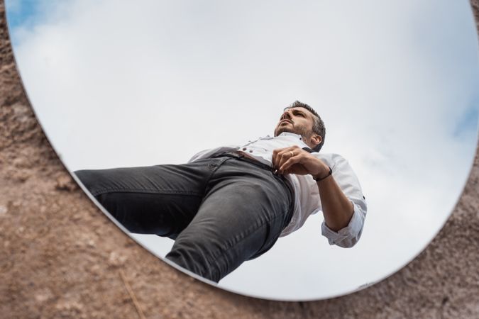 Fancy man reflecting in mirror on ground