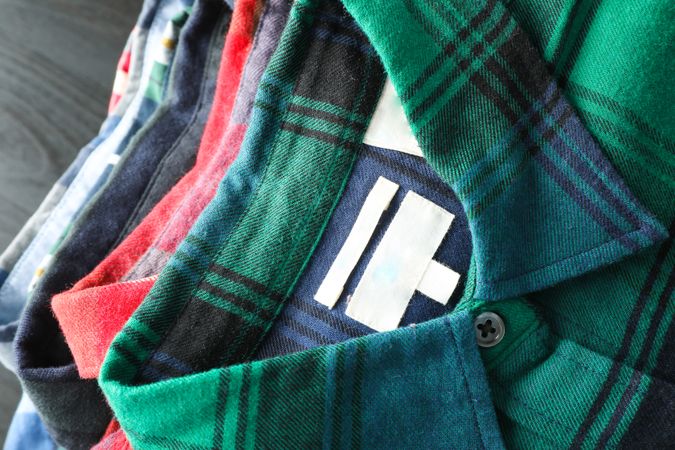 Stack of colorful shirts on table, space for text