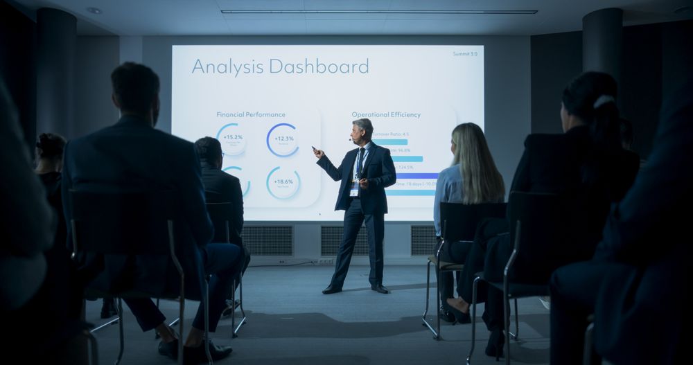 White Male CEO Giving Presentation to Diverse Audience of Businesspeople At International Business Conference.