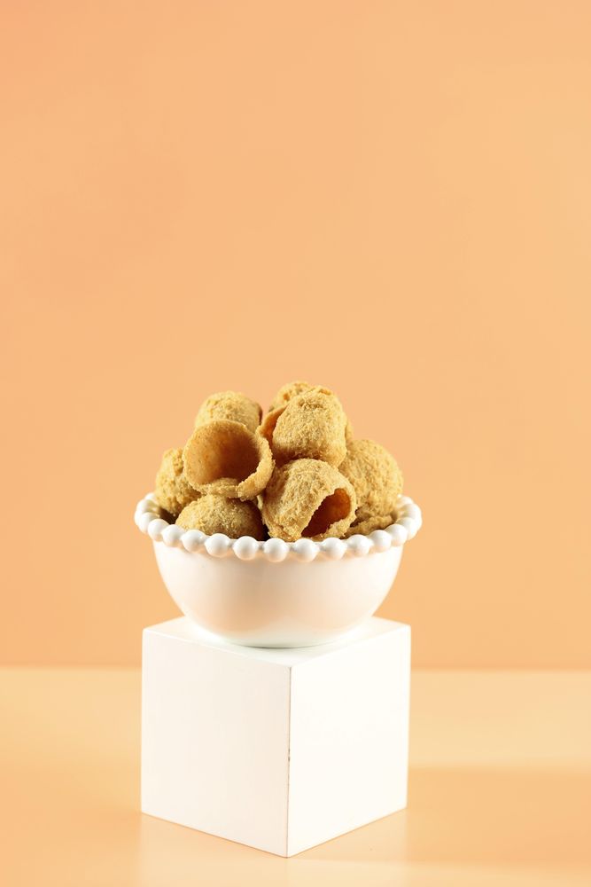 Bowl of crispy tofu on peach background