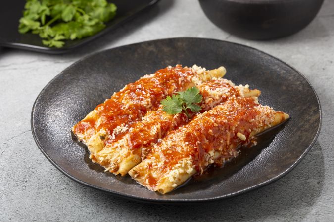 Pancakes stuffed with minced meat and topped with tomato sauce and grated cheese.